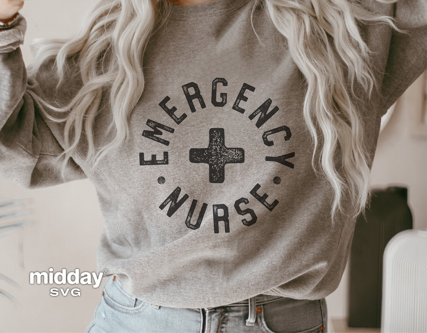 Woman wearing a gray sweatshirt with 'Emergency Nurse' text and a medical cross graphic.