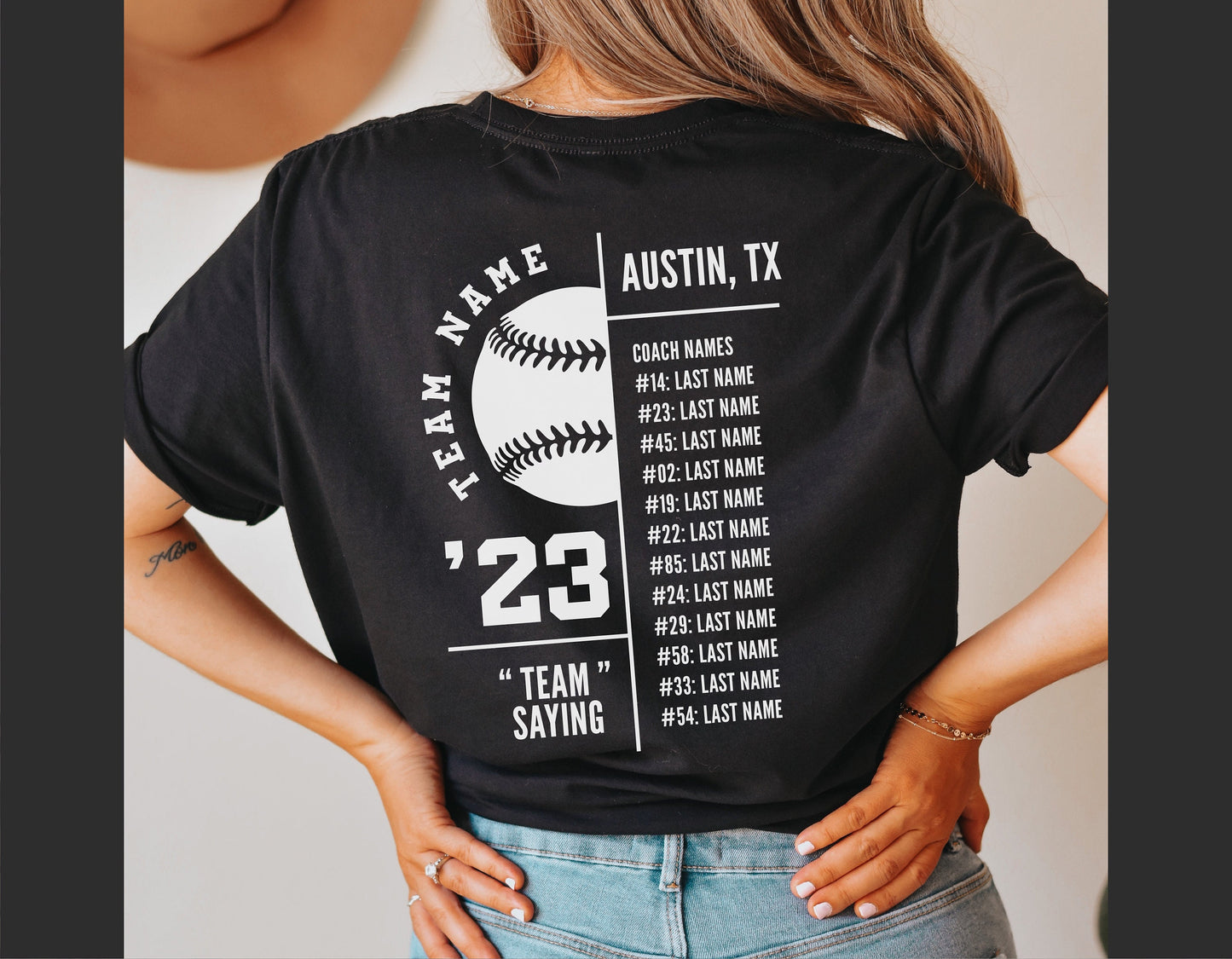 Back view of a person wearing a black t-shirt with a baseball team roster design, featuring team name and player numbers in white text.