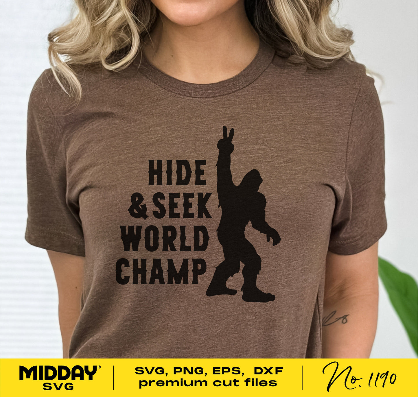 "Hide & Seek World Champ" brown t-shirt featuring a waving Bigfoot silhouette, suitable for camping and outdoors enthusiasts.