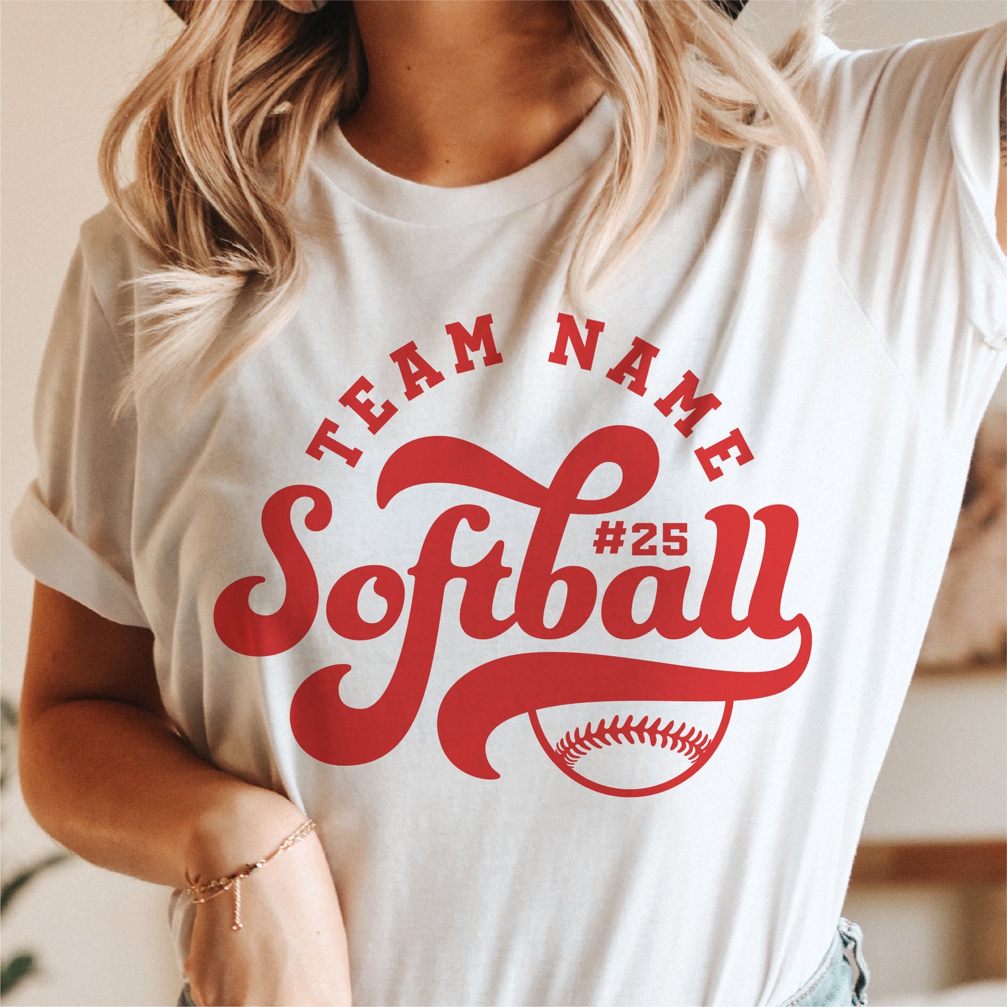 Woman wearing a t-shirt with retro softball team design, featuring customizable team name and player number in red text.
