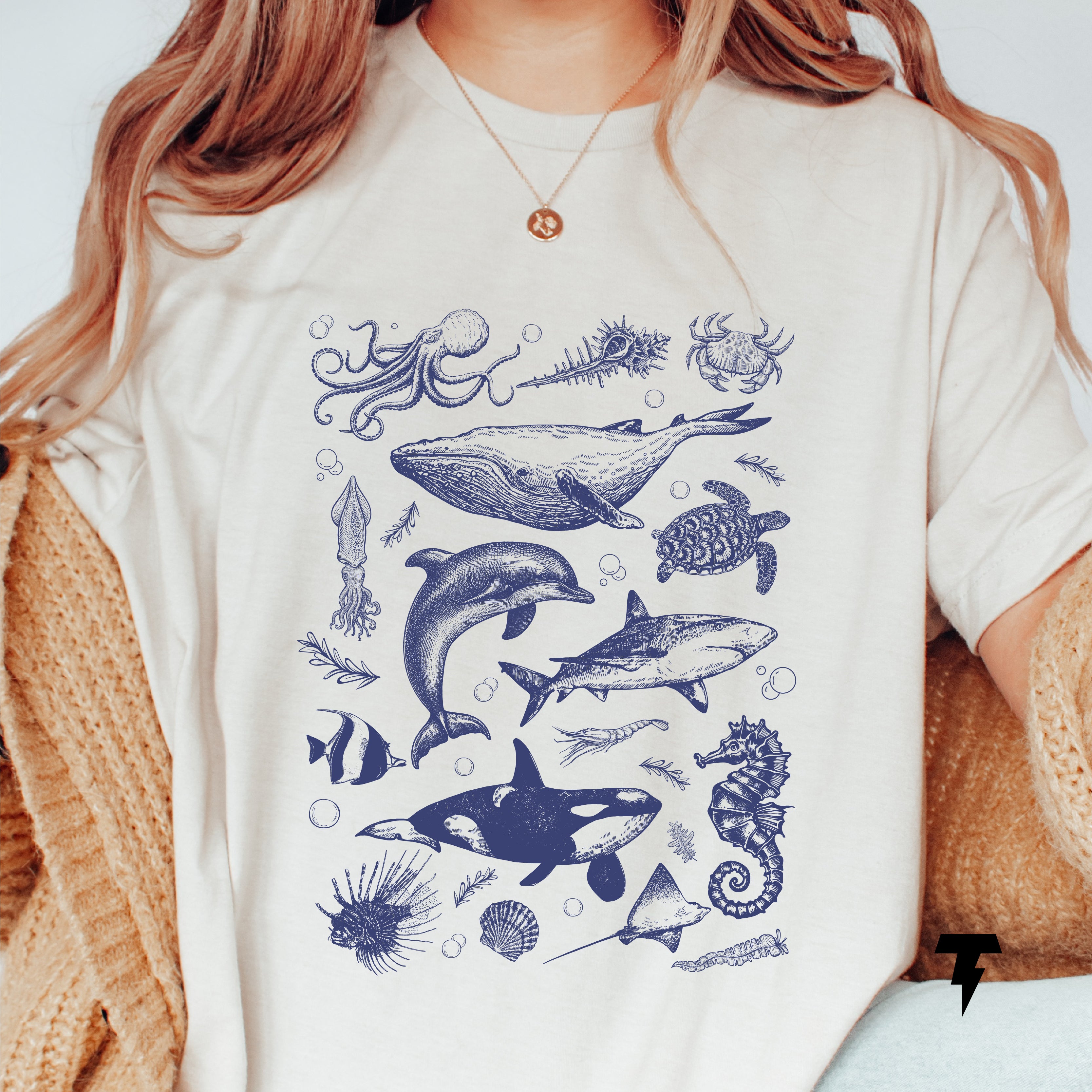 a woman wearing a t - shirt with a picture of dolphins and other marine animals