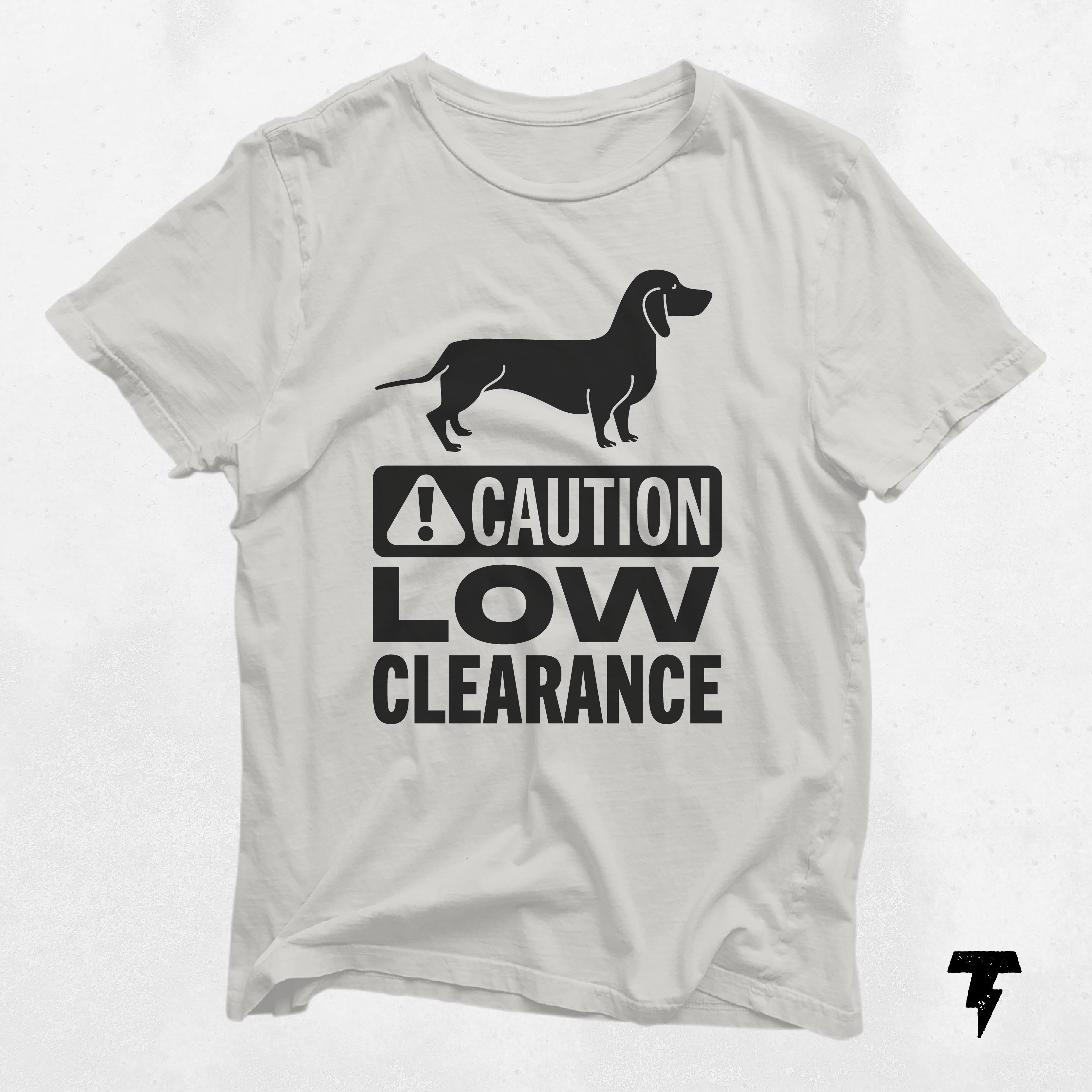 a white t - shirt with a black dog on it that says caution low clearance