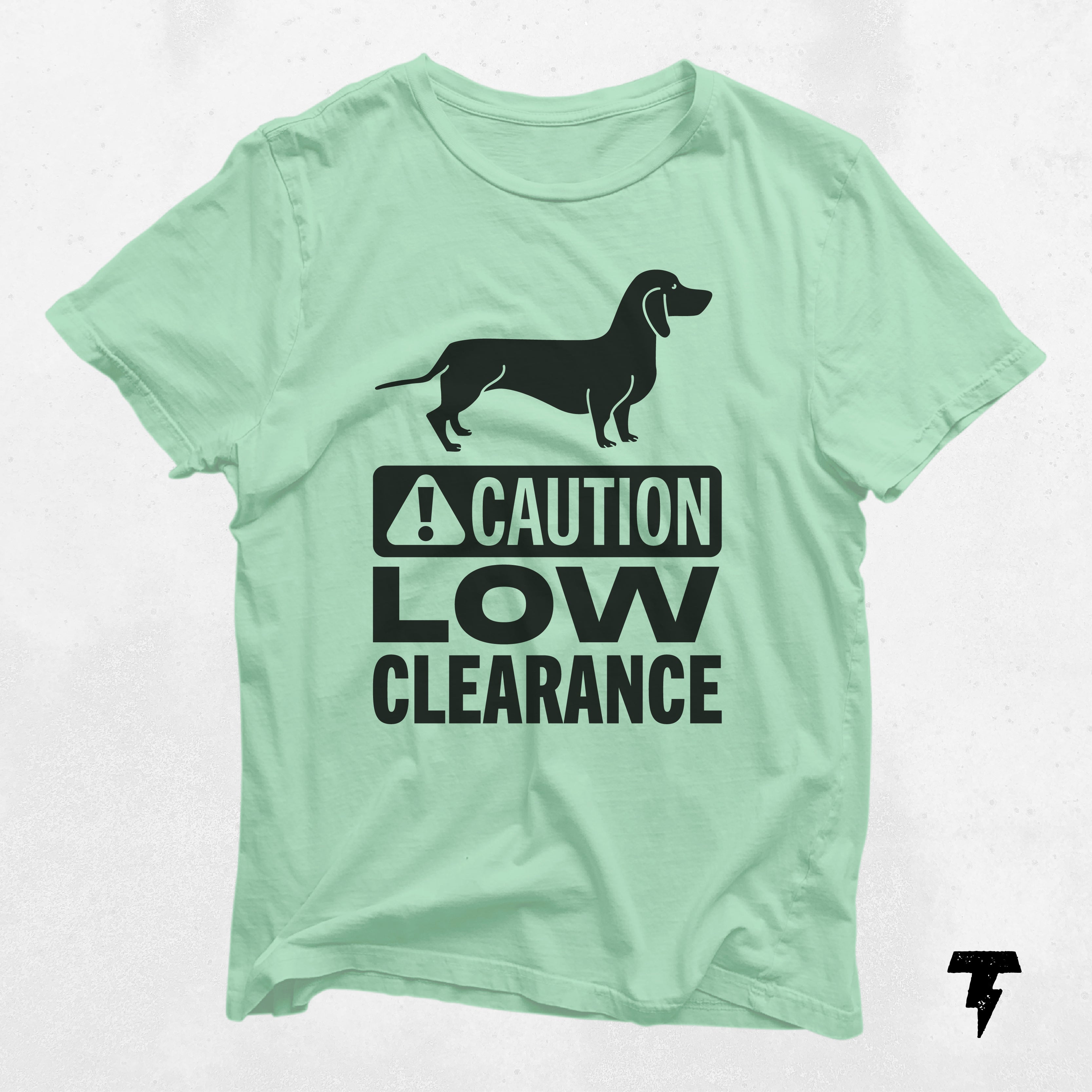 a green t - shirt with a black dog saying caution low clearance