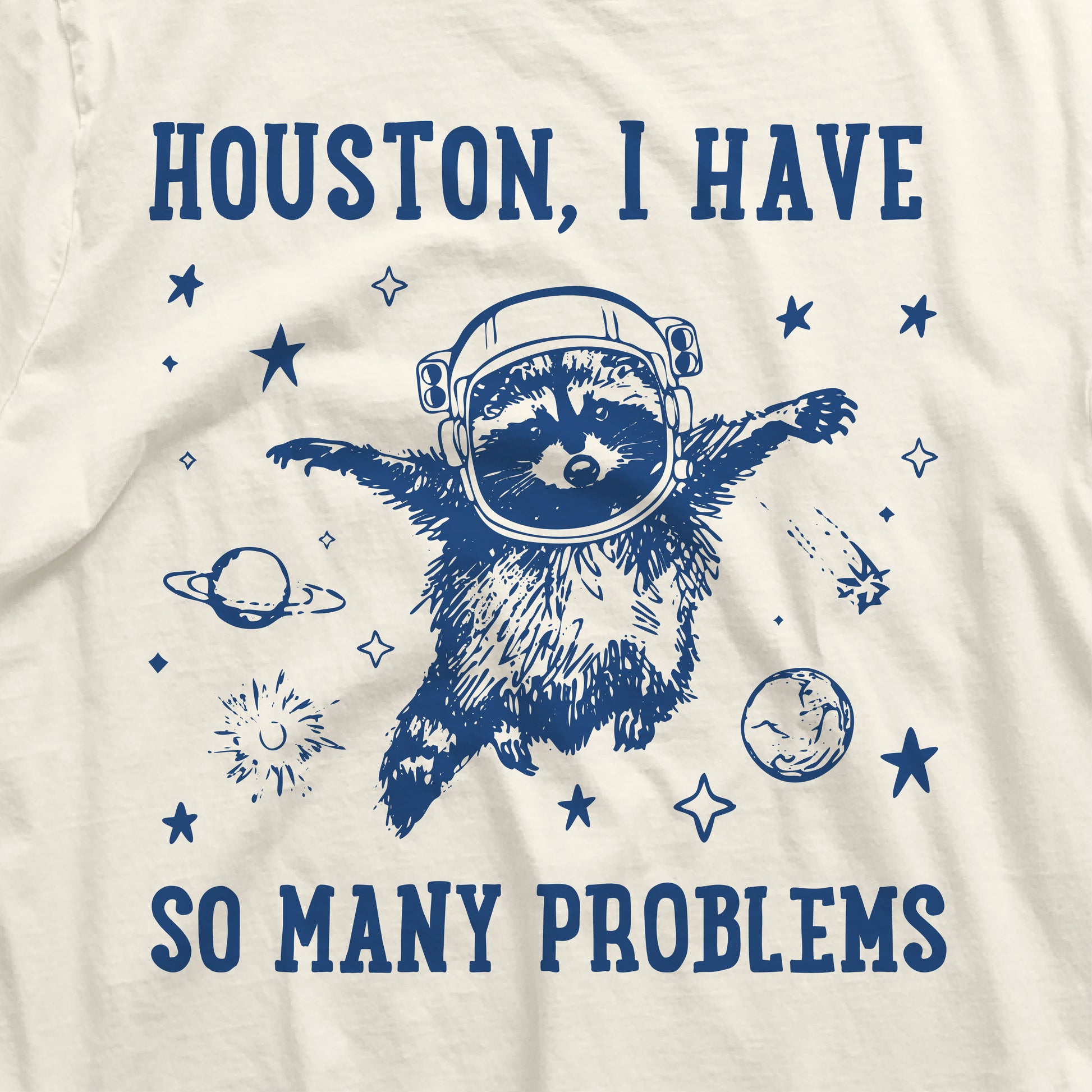 "Houston I Have So Many Problems" t-shirt featuring raccoon astronaut in space with planets and stars.
