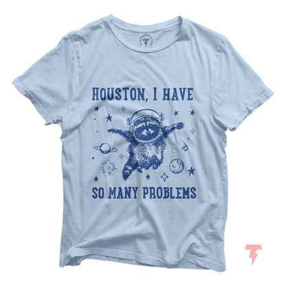 Houston I Have So Many Problems t-shirt featuring a raccoon astronaut floating in space, surrounded by stars and planets.