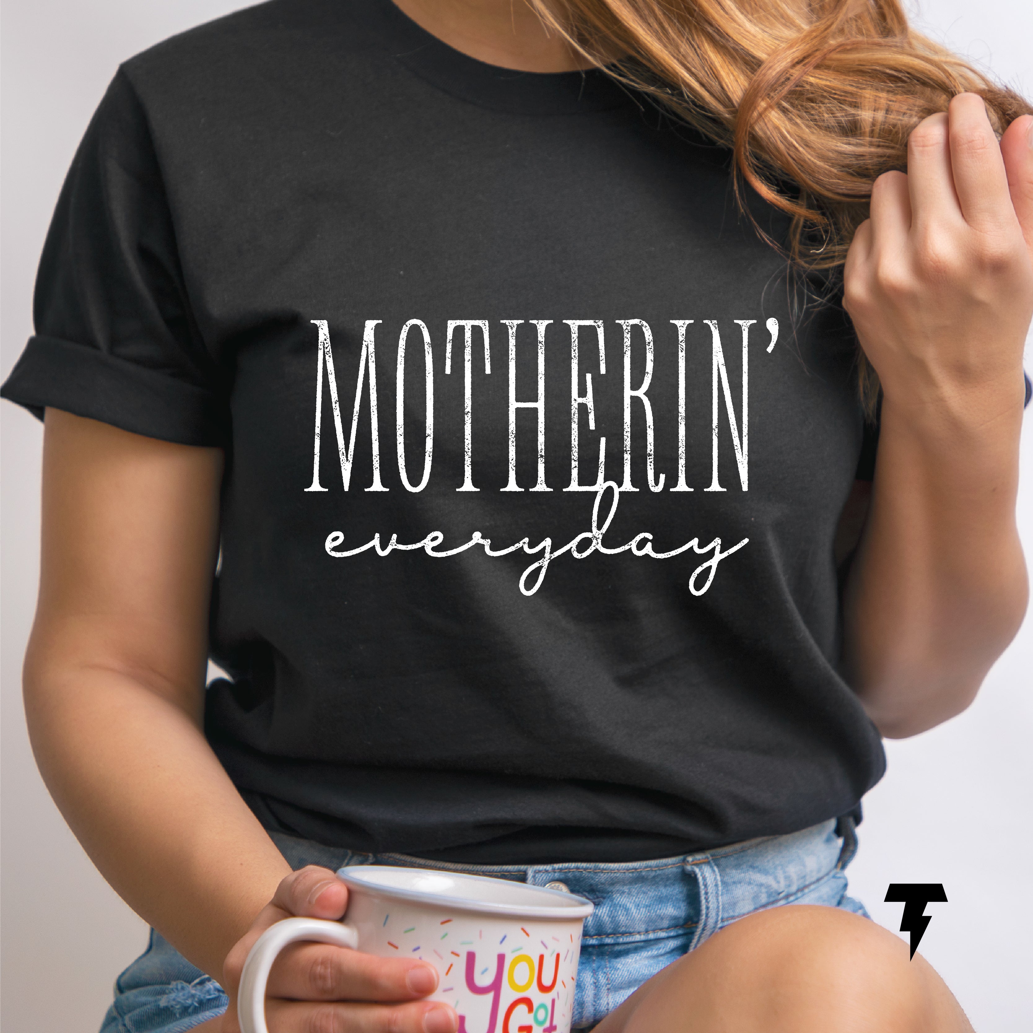 a woman is holding a coffee mug and wearing a t - shirt that says,