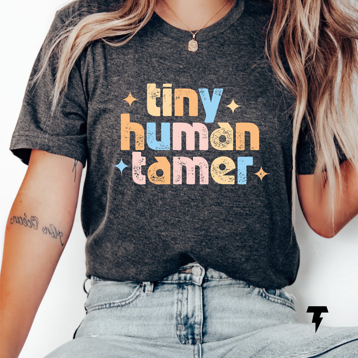 Funny teacher shirt with 'Tiny Human Tamer' text, ideal for pre-k, kindergarten, or daycare teachers, made of 100% cotton.