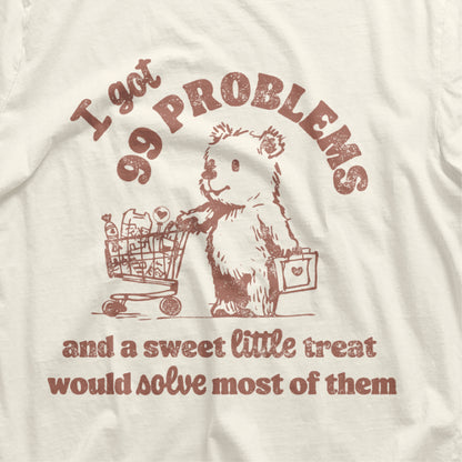 Vintage t-shirt with a cartoon bear, shopping cart, and humorous text '99 Problems and a Sweet Little Treat Would Solve Most of Them'