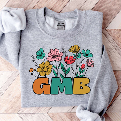 Gray sweatshirt with colorful floral design and 'GMB' text, ideal for cozy mornings and casual outings.
