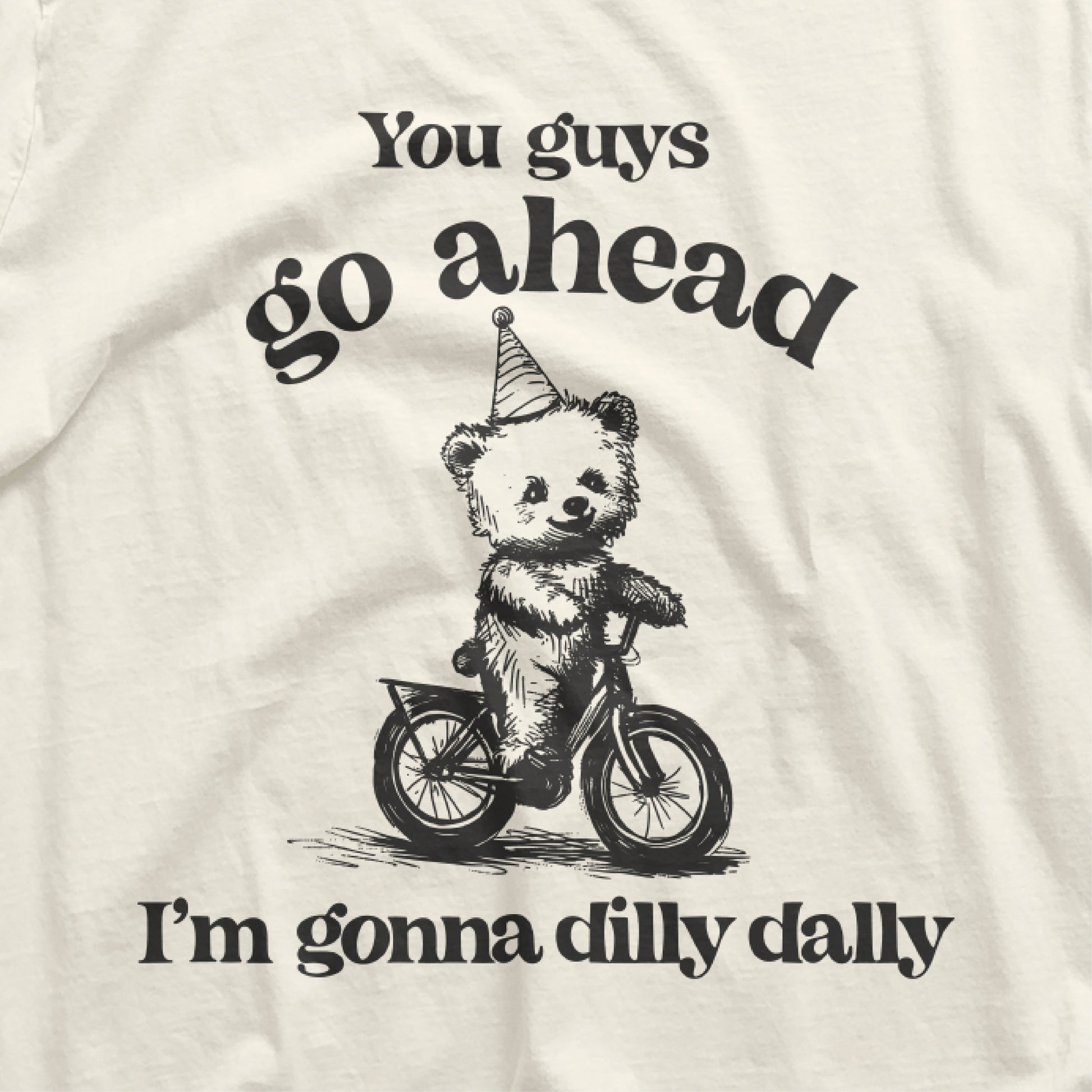Go Ahead I Am Gonna Dilly Dally t-shirt with bear riding bike graphic and funny 90s saying, perfect for free spirits and hobbyists.