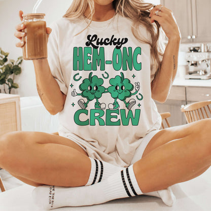 "Woman wearing Lucky HEM-ONC Crew St. Patrick's Day nursing shirt, holding a drink."
