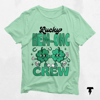 Lucky HEM-ONC Crew St. Patrick's Day shirt with cheerful shamrock design for nurses and oncologists. Festive nursing tee.
