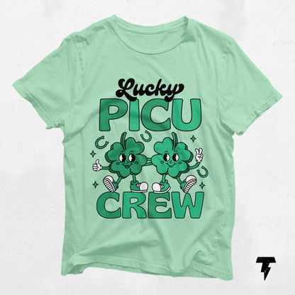 Lucky PICU Crew St. Patrick's Day shirt with clover graphics, perfect for pediatric care professionals. 100% lightweight cotton.