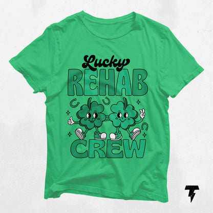 Green Lucky Rehab Crew St. Patrick's Day shirt with cartoon clovers, ideal for Speech Language Pathology, Occupational, and Physical Therapy fans.