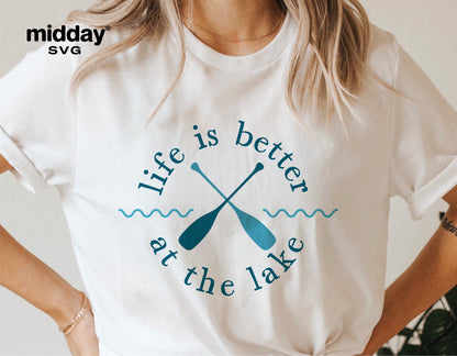 Woman wearing a white t-shirt with 'Life is better at the lake' design featuring crossed paddles; ideal for lake-themed decor.