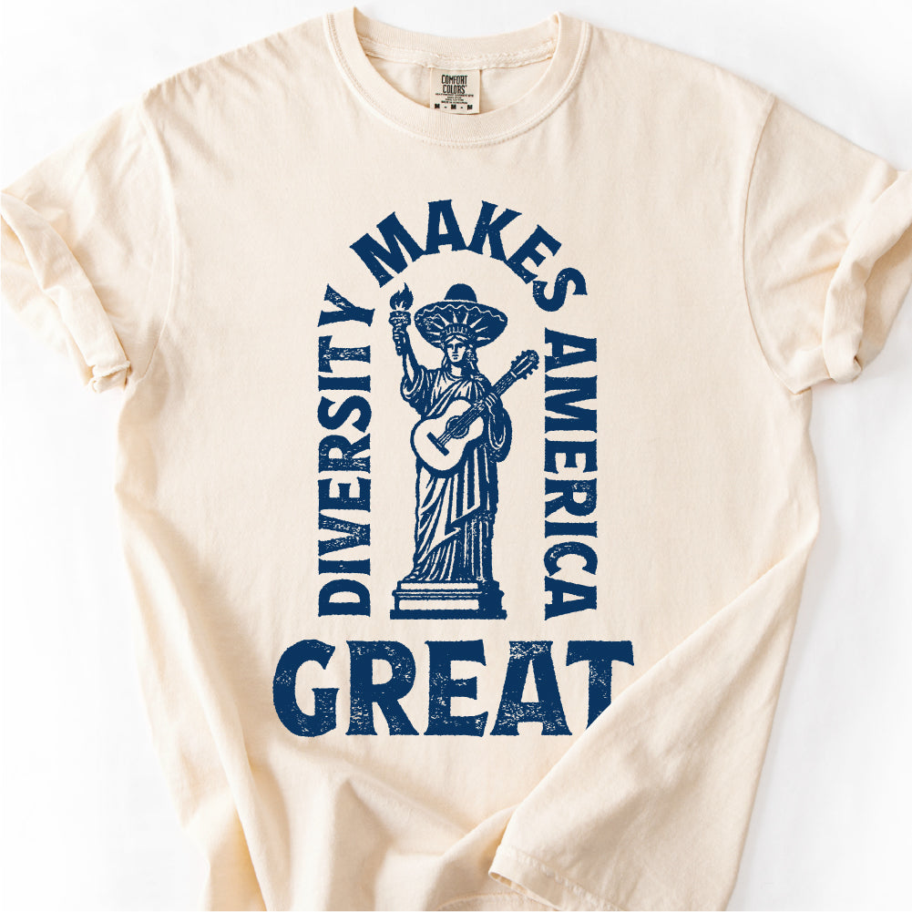 A white t-shirt with a graphic design featuring a figure holding a guitar and the text "DIVERSITY MAKES AMERICA GREAT" printed on it.