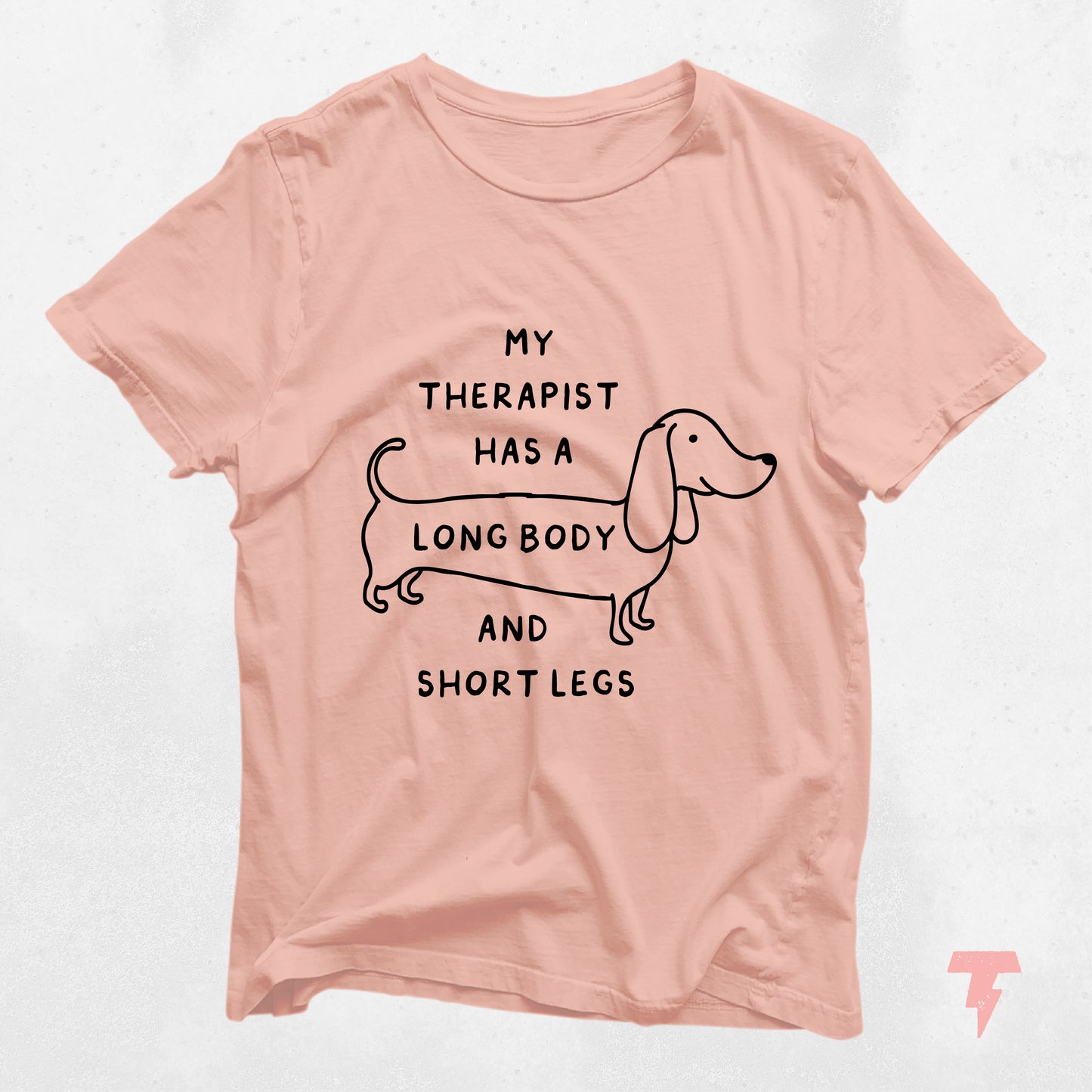 Peach t-shirt with a dachshund illustration and text 'My Therapist Has a Long Body and Short Legs'