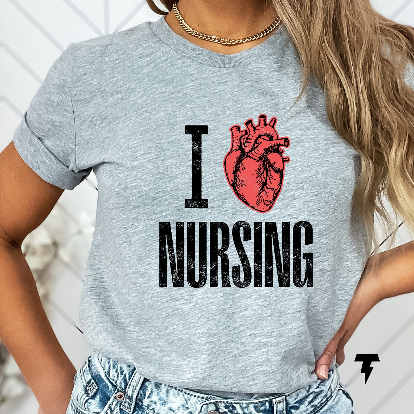 Woman wearing gray 'I Love Heart Nursing' shirt with rolled sleeves and a gold chain necklace.