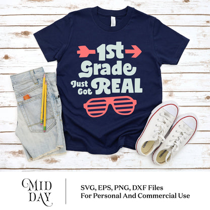 Navy shirt with '1st Grade Just Got Real' design, cut files for Cricut, next to denim shorts and white sneakers, perfect for back to school.