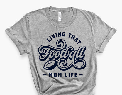 Gray t-shirt with 'Living That Football Mom Life' design in navy, ideal for football fan moms. Perfect for game days and sports events.