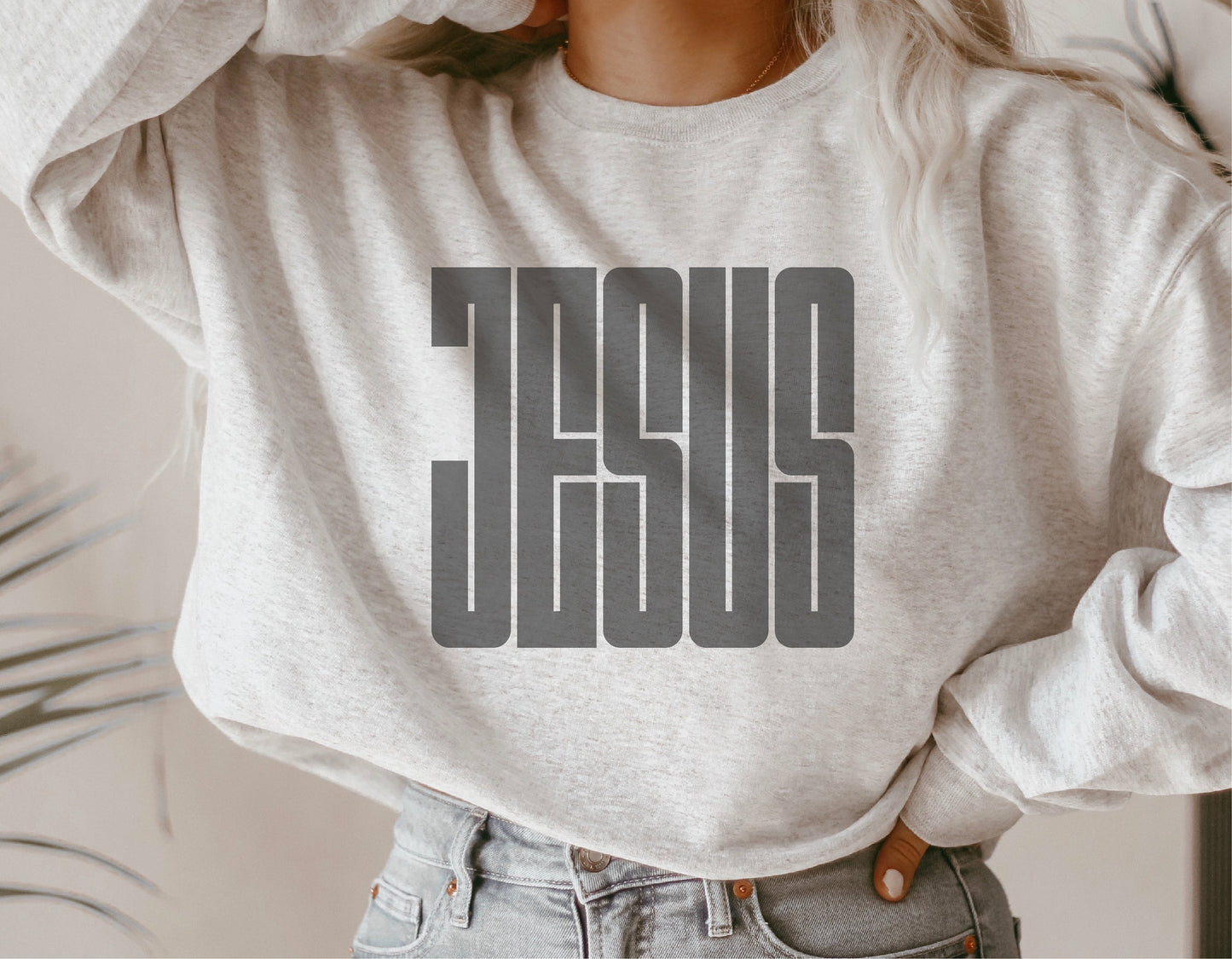 White sweatshirt with bold 'Jesus' graphic design, perfect for religious expression and casual wear.