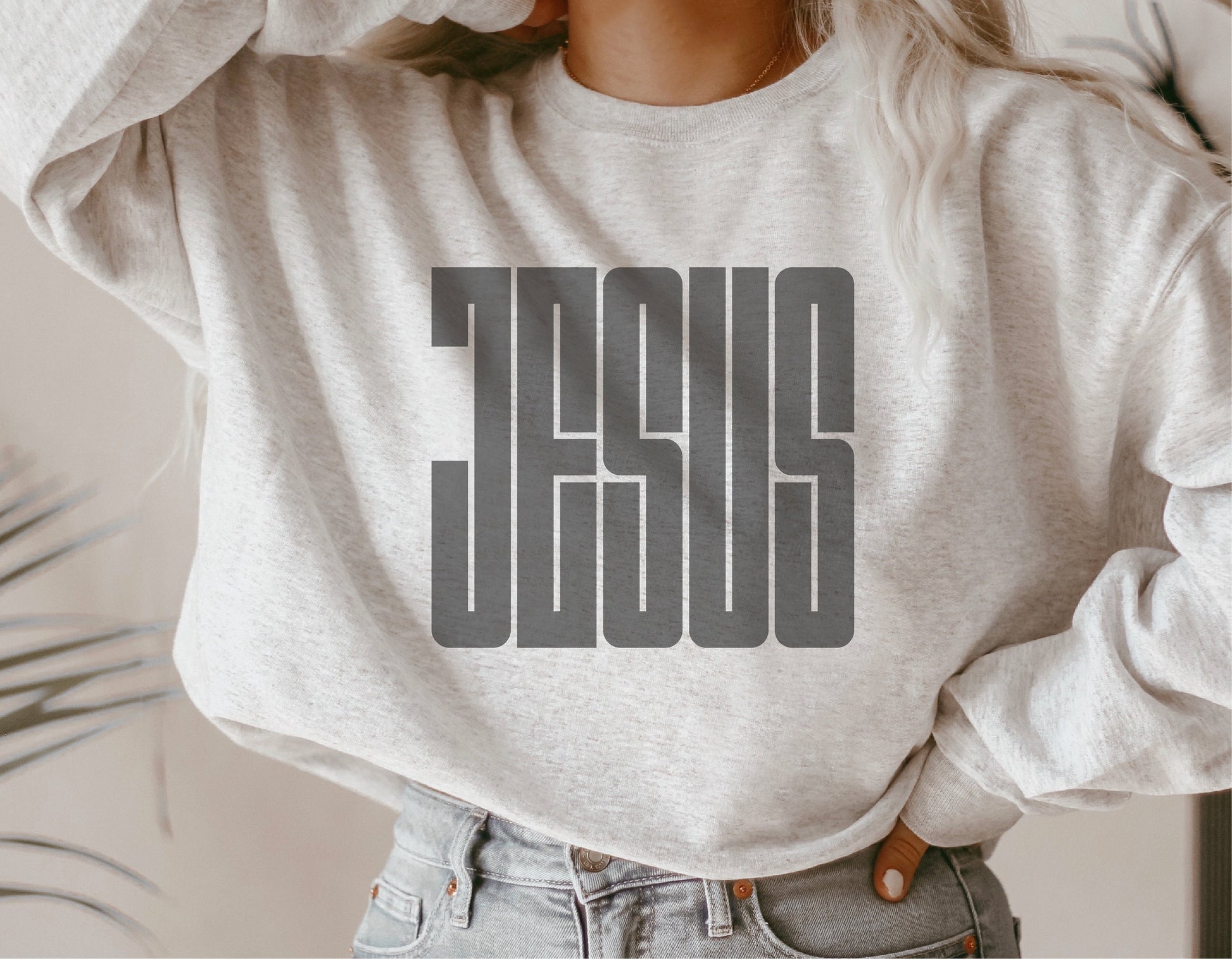 White sweatshirt with bold 'Jesus' graphic design, perfect for religious expression and casual wear.