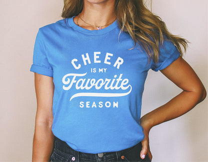 Woman wearing blue t-shirt with 'Cheer is My Favorite Season' slogan, perfect for cheerleading fans and enthusiasts.