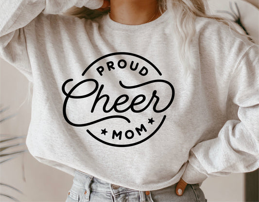 Woman wearing a sweater with 'Proud Cheer Mom' design, showcasing cheerleader support. Ideal for SVG, cut files, sublimation projects.