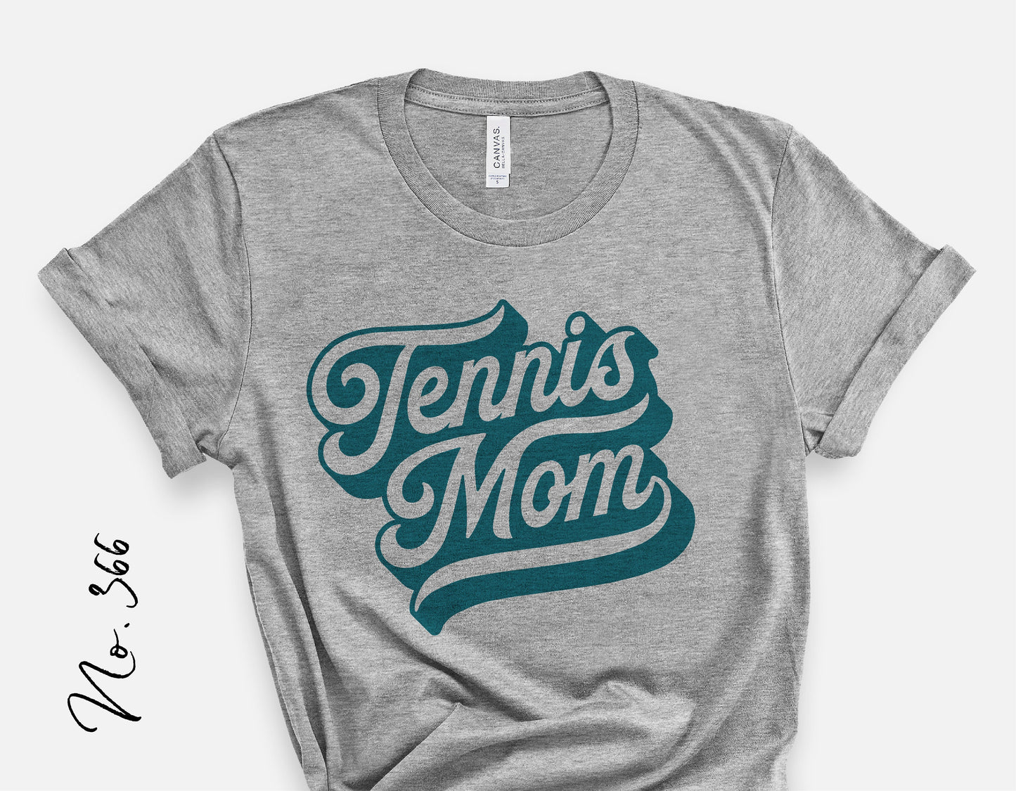 Heather gray shirt with 'Tennis Mom' graphic in teal lettering, perfect for sporty tennis fans and mom enthusiasts.