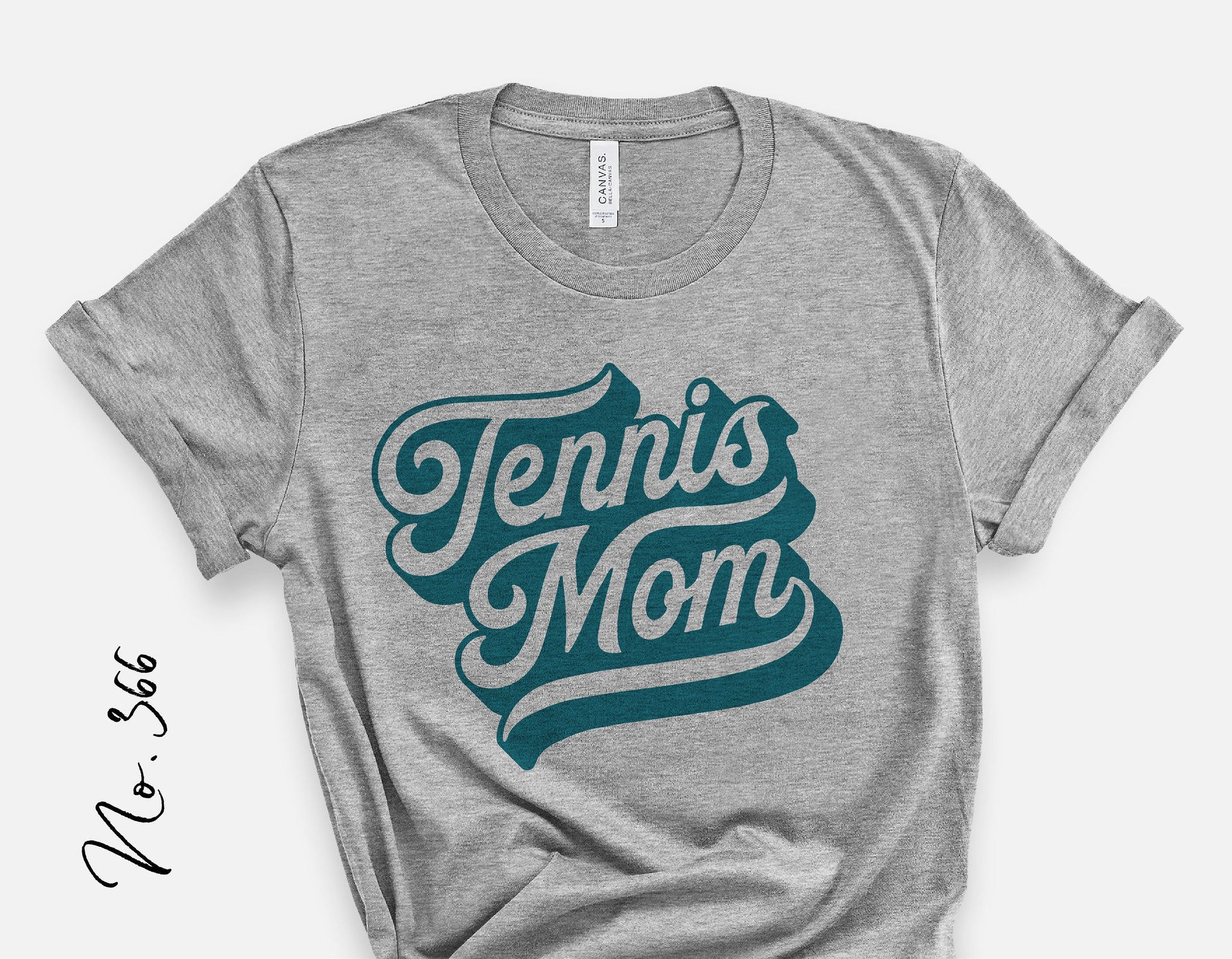Heather gray shirt with 'Tennis Mom' graphic in teal lettering, perfect for sporty tennis fans and mom enthusiasts.