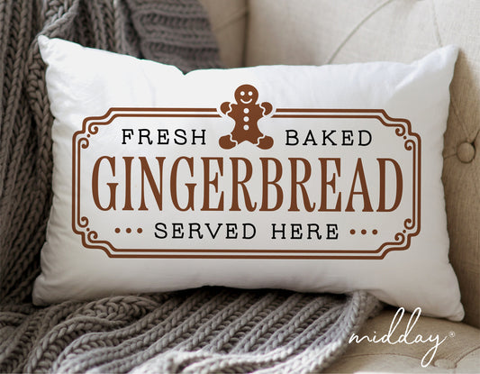 Decorative pillow featuring a gingerbread man with text 'Fresh Baked Gingerbread Served Here' on a couch.