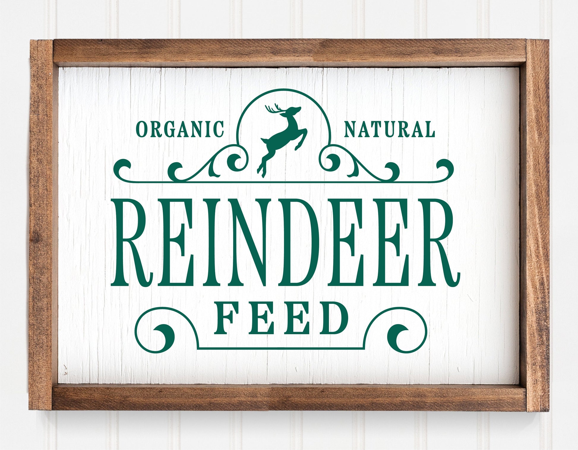 Rustic "Reindeer Feed" Christmas sign ornament with green lettering and wooden frame for holiday decor.
