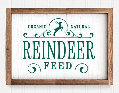 Rustic "Reindeer Feed" Christmas sign ornament with green lettering and wooden frame for holiday decor.