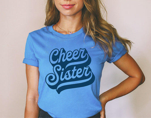 Woman wearing blue T-shirt with 'Cheer Sister' in retro cursive. Perfect for cheerleading and team spirit enthusiasts. Available in SVG format.