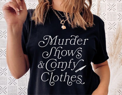 Woman wearing 'Murder Shows & Comfy Clothes' black t-shirt, featuring a playful true crime theme. Ideal for Halloween and sublimation design.