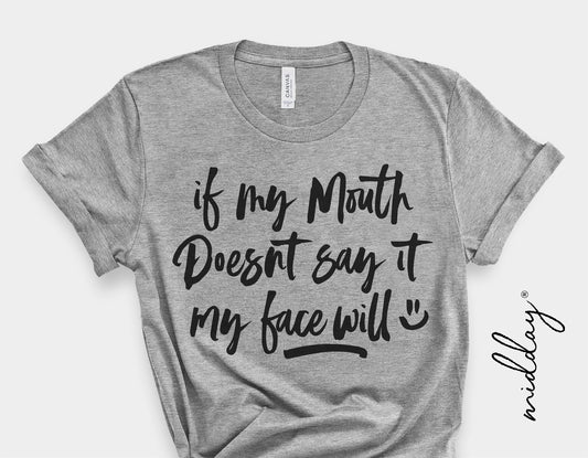 Gray t-shirt with 'If My Mouth Doesn't Say It, My Face Will' text printed in black, sarcastic and humorous design.