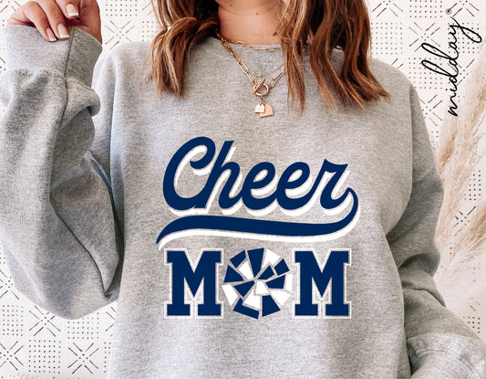 Woman wearing grey sweatshirt with 'Cheer Mom' design featuring blue text and pom pom graphic, suitable for cheerleader SVG projects.