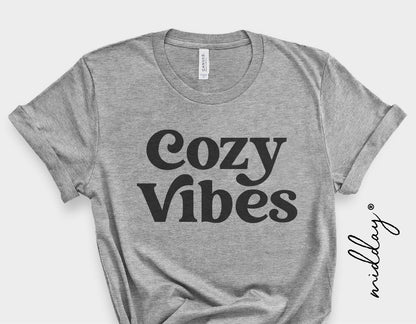 Gray t-shirt with 'Cozy Vibes' text, showcasing retro typography style, perfect for cozy autumn and winter fashion.