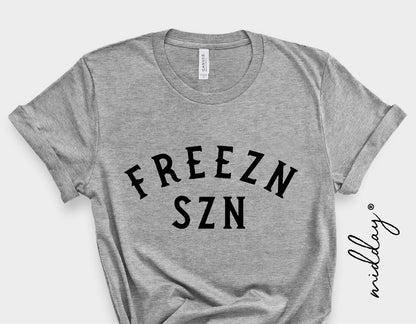 Gray t-shirt with "FREEZN SZN" text, ideal for winter fashion and holiday-themed gifts.