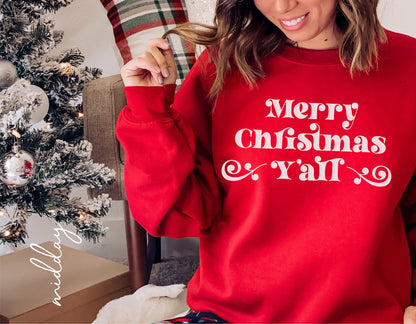 Woman wearing red 'Merry Christmas Y'all' sweatshirt next to decorated Christmas tree, perfect for holiday cheer and style.