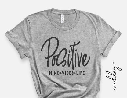 Gray t-shirt with 'Positive Mind Vibes Life' design in black script; inspirational SVG for Cricut crafting.