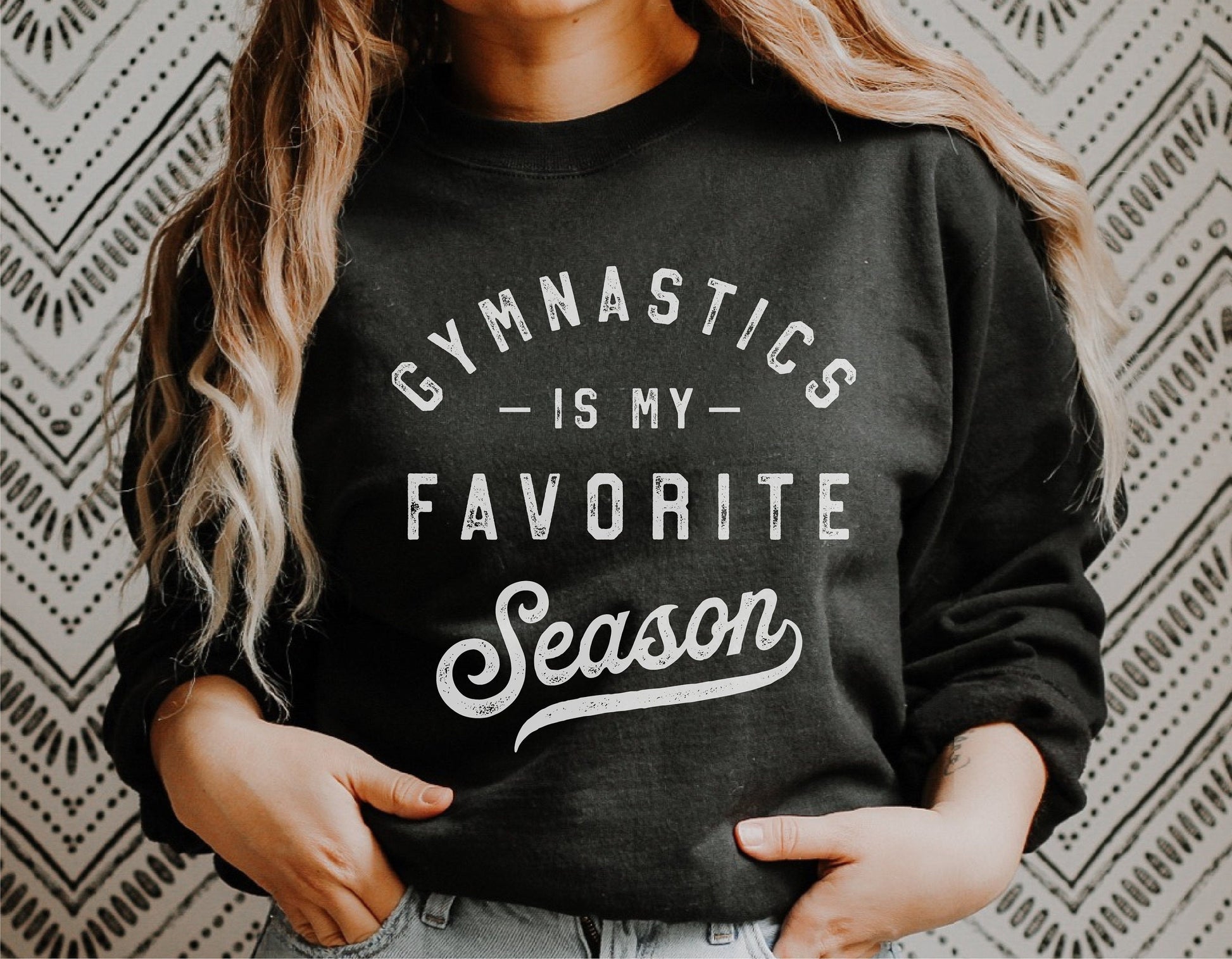 Person wearing a black sweatshirt with 'Gymnastics is my Favorite Season' text design. Ideal for gymnastics enthusiasts and Cricut projects.