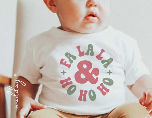 Baby wearing a white shirt with 'Fa La La & Ho Ho Ho' print in red and green, ideal for first Christmas holiday.