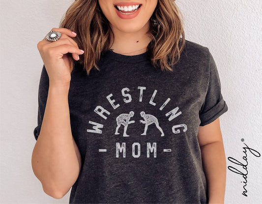 Woman wearing a black 'Wrestling Mom' t-shirt with wrestling figures, showcasing casual sports-themed apparel.
