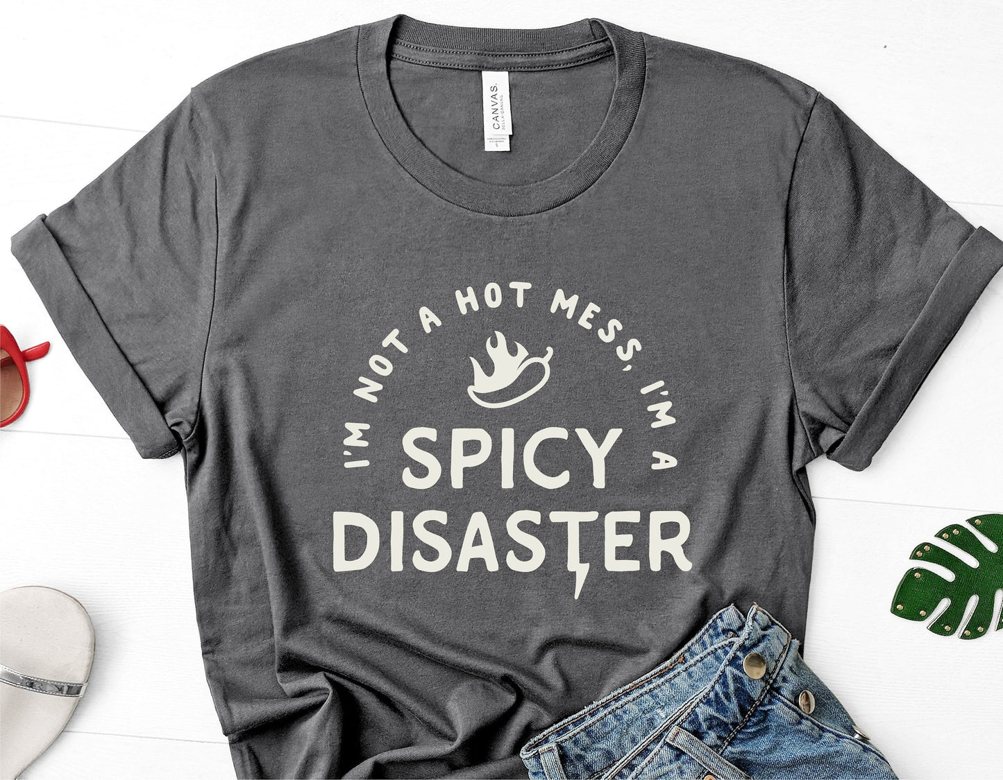 Gray t-shirt with 'I'm Not A Hot Mess, I'm A Spicy Disaster' text, perfect for sassy style lovers, humorous fashion statement.