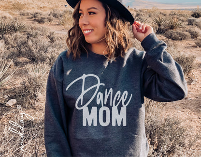 Woman wearing a 'Dance Mom' sweatshirt standing in a desert landscape