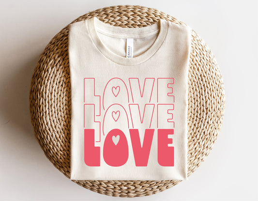 Valentine's Day t-shirt with 'Love Love Love' design in pink, perfect for Cricut and Silhouette projects, displayed on wicker surface.