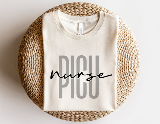 PICU nurse shirt folded on a wicker basket, featuring a stylish font design, perfect for Cricut and sublimation projects.