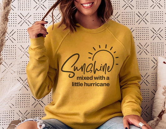 Woman wearing a yellow sweater with 'Sunshine mixed with a little hurricane' text, casual outfit, funny silhouette design for Cricut.