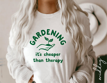 Woman wearing a humorous gardening-themed shirt that says "Gardening it's cheaper than therapy" with a plant graphic.